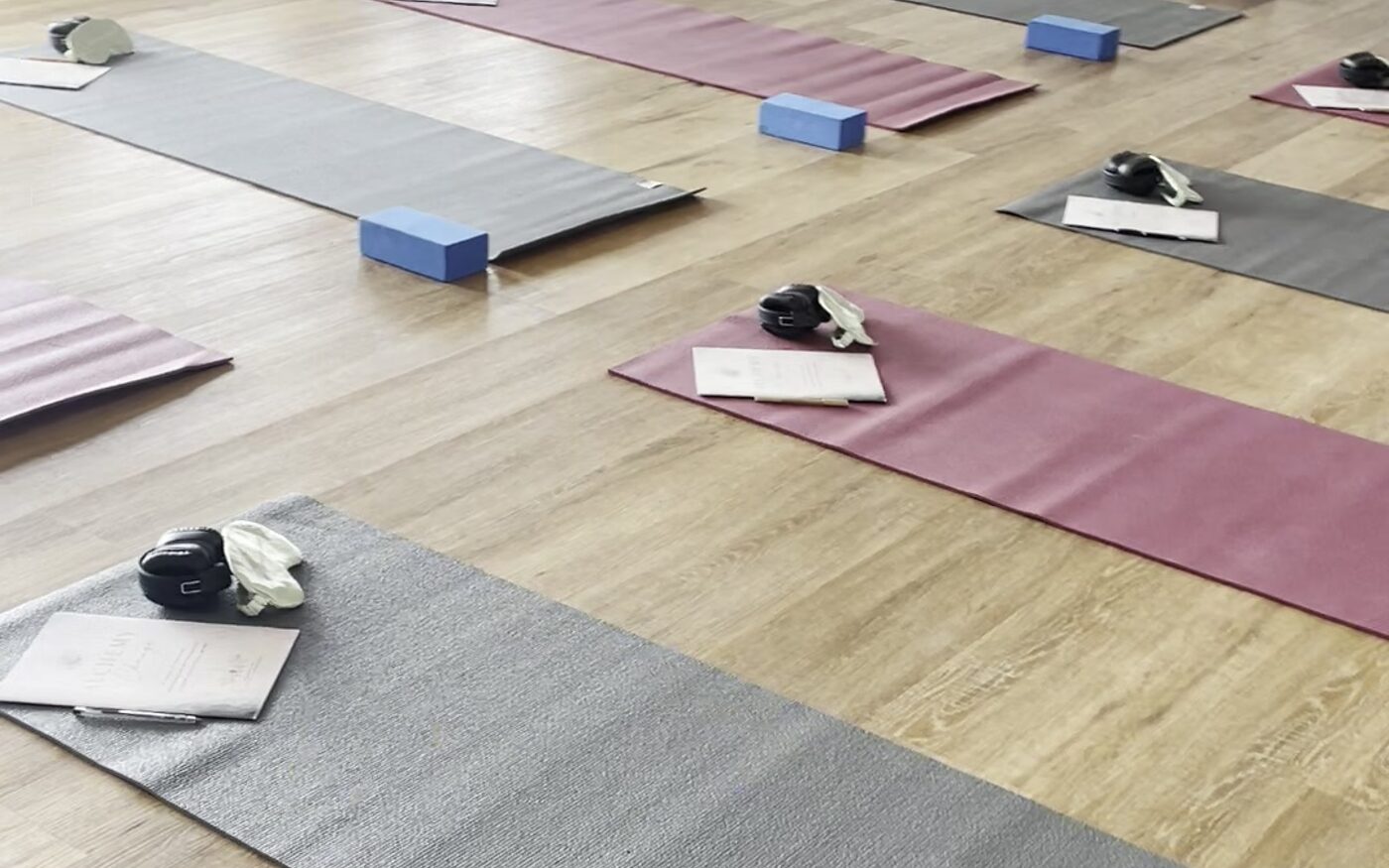 Yoga mats, blocks and eye masks laid out in a bright studio